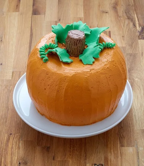 Giant pumpkin cake made from two bundt cakes, with a cake stem and fondant leaves (Anna Olson)