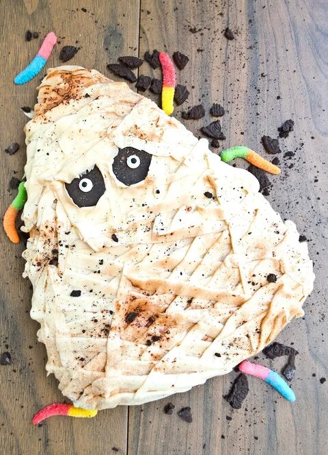 Mummy cake with white buttercream bandages and candy eyes (CakeWhiz)