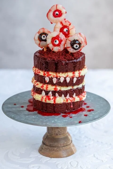 Red velvet eyeball cake with lychee eyeballs on skewers and red drips (Supergolden Bakes)
