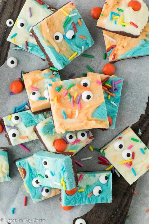 Squares of blue, white and orange swirled fudge topped with candy eyes and sprinkles (Love In My Oven)