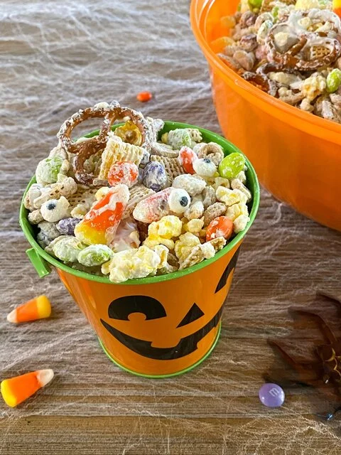 Monster Munch mix of popcorn, pretzels, cereal, candy corn and candy eyes in an orange jack-o’-lantern bucket (Life Made Simple)