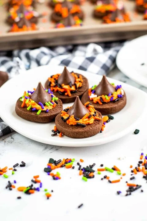 Chocolate witch hat cookies with Hershey’s Kiss points and orange buttercream bands with sprinkles (Crayons & Cravings)